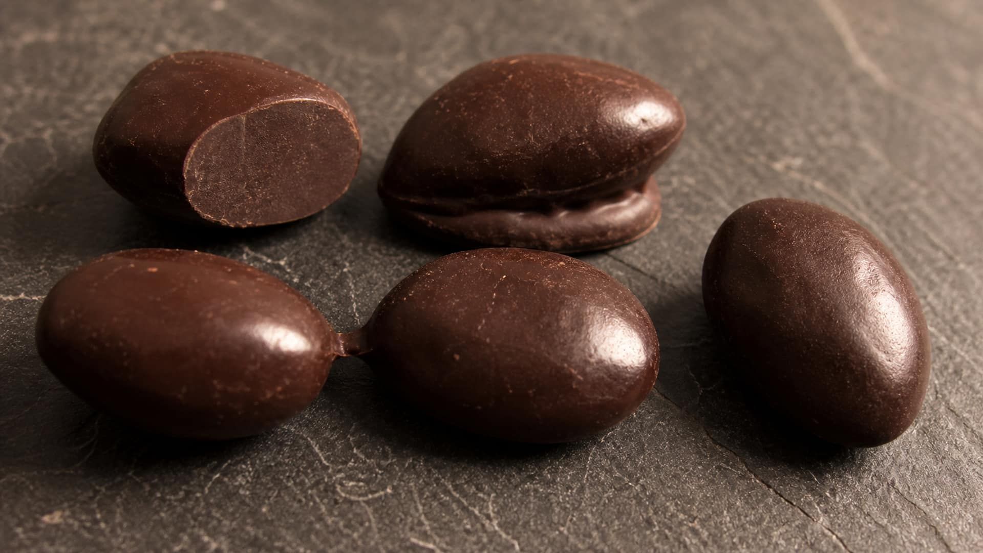 Dragées with uneven coating showing flat spots, pooling, and bridging.