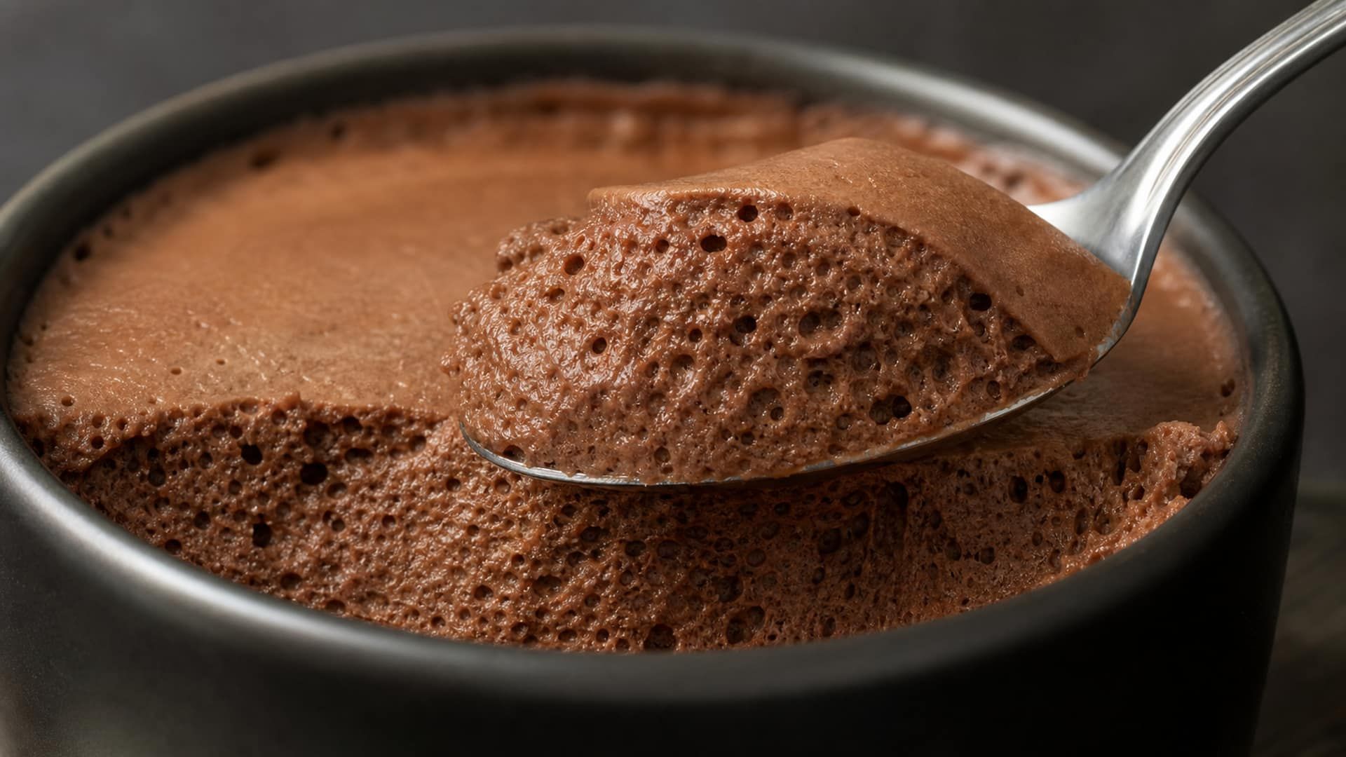 Macro of an airy chocolate mousse showing a lattice of fine air bubbles.